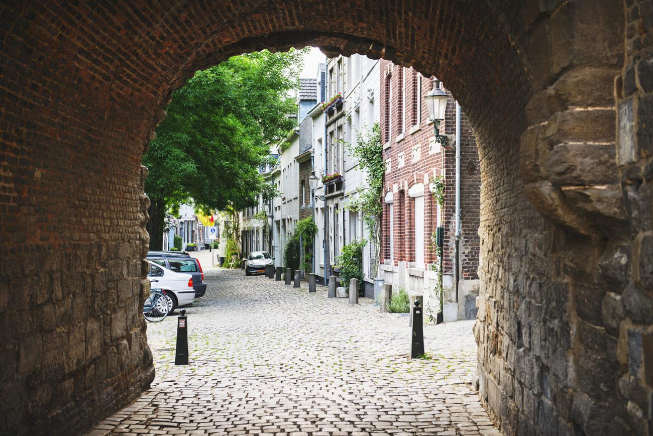 doorkijkje door poort in muur