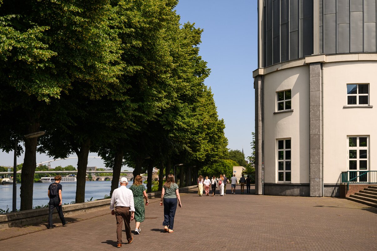 Een konisch gebouw met wit en grijs langs de kade bij water