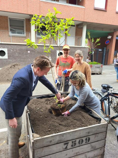 Plant wordt in bak gedaan door 2 mensen