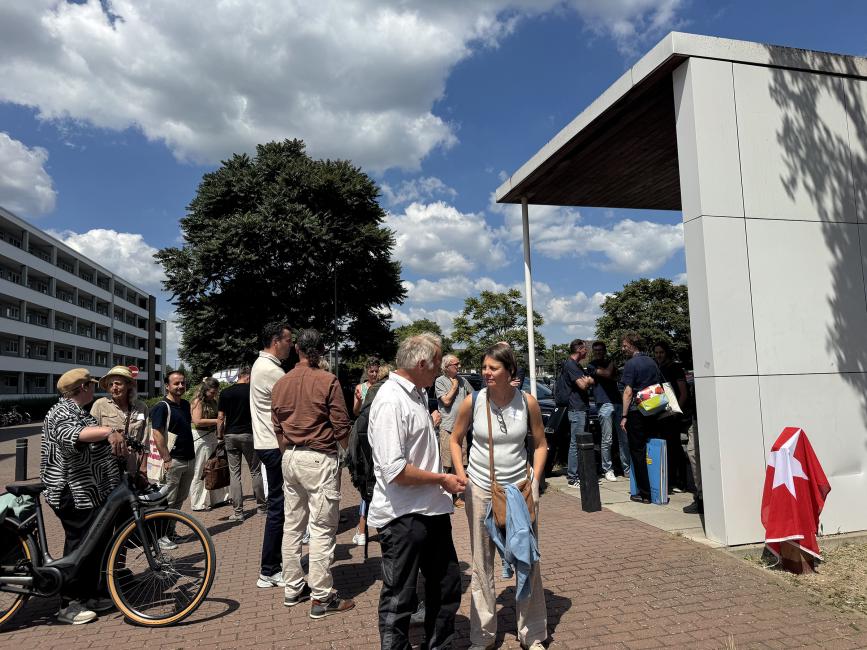 groep mensen op ene plek bij een witte overkapping
