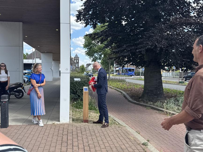 man bij een paal met een bord erop